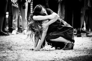 Deux danseuses accroupies et enlacées au sol, entourées de fils, en noir et blanc — Fibre