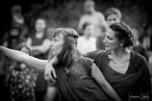 Deux danseuses en robes de toile, un bras tendu vers le public, en noir et blanc — Fibre
