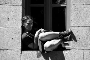 Danseuse recroquevillée dans l'embrasure d'une fenêtre, en noir et blanc — Fibre
