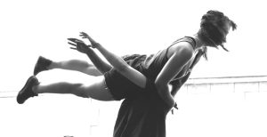 Danseuse portée sur le dos d'une autre, jambes tendues, en contre-jour — Fibre