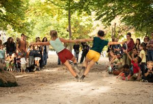 Deux danseuses en équilibre, bras tendus et mains jointes, au centre du cercle formé par le public — Hors Sol