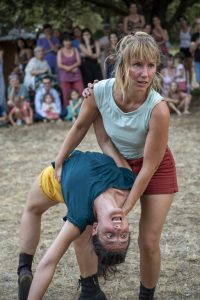 Danseuse soutenant sa partenaire renversée en arrière, bouche ouverte, devant le public — Hors Sol