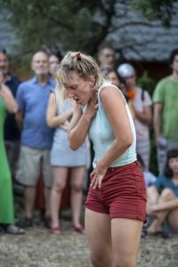 Danseuse essoufflée, main à la gorge et buste penché, au milieu des spectateurs — Hors Sol
