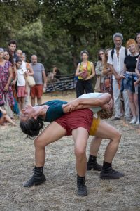 Deux danseuses dos à dos, tête renversée en arrière, devant le public debout — Hors Sol