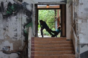 Deux danseuses dans l'embrasure d'une porte d'un bâtiment désaffecté, escalier au premier plan — Hors Sol
