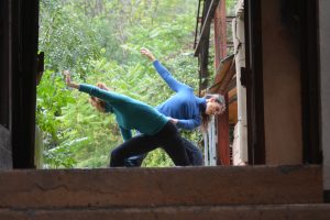 Deux danseuses en appui l'une contre l'autre, bras déployés, dans l'encadrement d'une fenêtre d'usine — Hors Sol