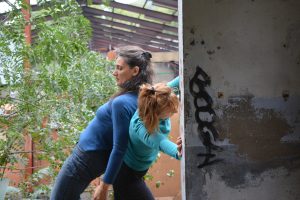 Deux danseuses adossées à un mur taggé d'un bâtiment en ruine envahi par la végétation — Hors Sol
