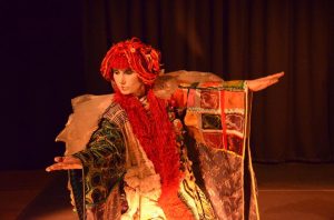 Interprète en kimono et perruque rouge, bras déployés sous une lumière chaude — Kimonoshima